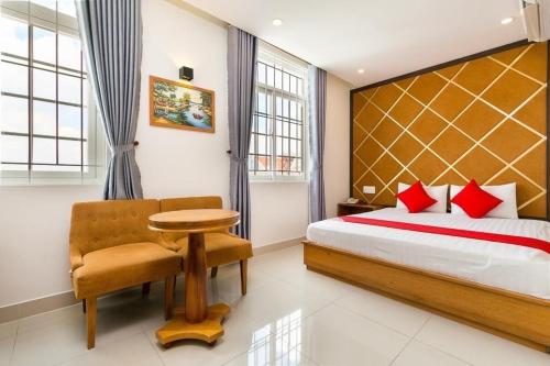 a bedroom with a bed and a table and a chair at khách sạn Thiên Cung in Ho Chi Minh City