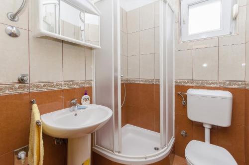 een badkamer met een douche, een wastafel en een toilet bij Apartment Zdravko in Srima