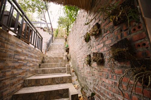 a brick wall with stairs next to a building at Ha Giang Creekside Lodging and Tours in Ha Giang