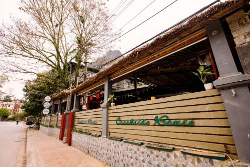 a building with a sign on the side of it at Ha Giang Creekside Lodging and Tours in Ha Giang