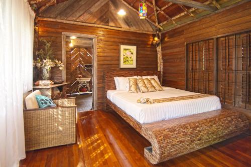 a bedroom with a bed in a wooden room at Fig Tree Hills Resort (花果山度假村) in Bayan Lepas