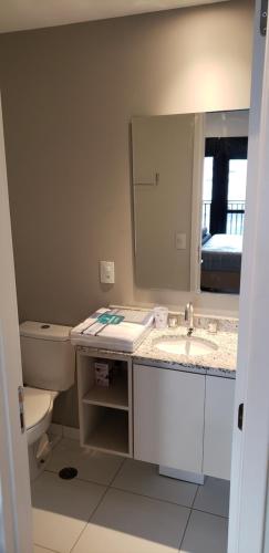 a bathroom with a sink and a toilet and a mirror at 68 Brand-new studio next to Paulista Av, fast wifi in Sao Paulo