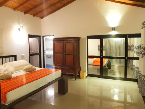 a bedroom with a bed and a dresser in it at Coconut Garden River Villa in Galle