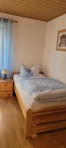 a bedroom with a bed with a wooden frame and a window at Bergsteiger in Sandberg