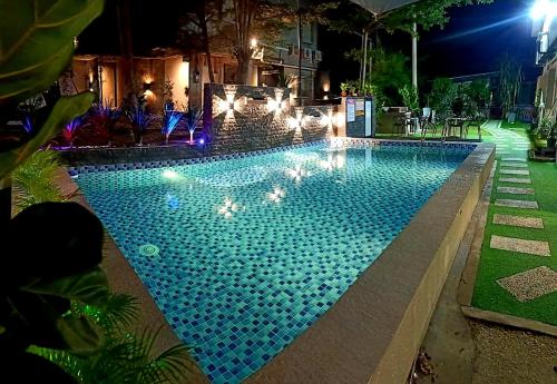 una gran piscina por la noche con luces en Tc theme park Guest house en Kuantan