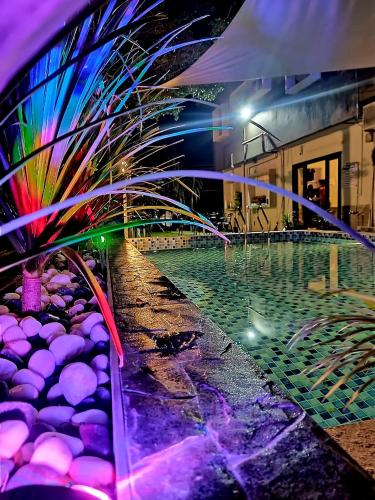 a pool at night with lights on a building at Tc theme park Guest house in Kuantan