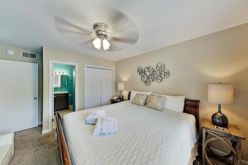 a bedroom with a white bed with a ceiling fan at Spa on Port Royal Sound II in Hilton Head Island