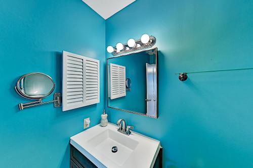 a blue bathroom with a sink and a mirror at Spa on Port Royal Sound II in Hilton Head Island