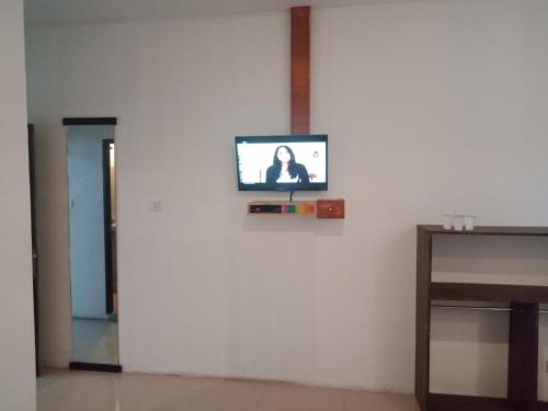 a television on a white wall in a room at Anyar in Mataram