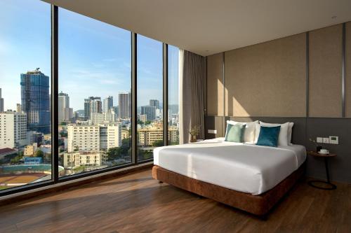 - une chambre avec un grand lit et de grandes fenêtres dans l'établissement Em Oi Boutique Hotel, à Nha Trang
