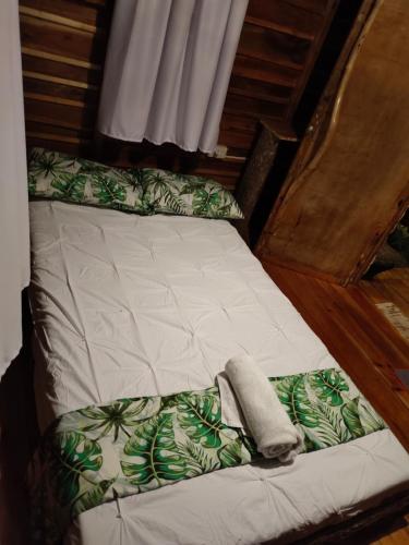 a bed with a green and white comforter at Payag n' Kapitan, Experience pinubre living in Siquijor