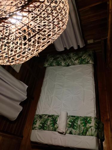 a small bed in a room under a chandelier at Payag n' Kapitan, Experience pinubre living in Siquijor