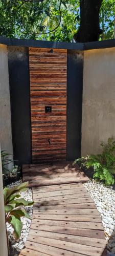 a wooden walkway with a wooden door in a garden at Bongo Bongo Divers in Dauin