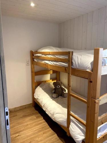 un ours en peluche assis sur la couchette inférieure d'un lit superposé dans l'établissement Appartement Alpin, à Bourg-Saint-Maurice