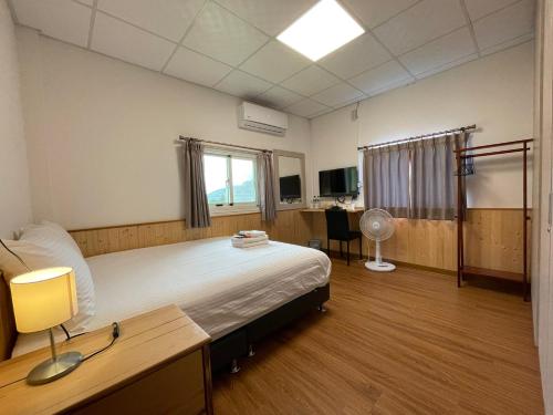 een ziekenhuiskamer met een groot bed en een bureau bij Lao Fan Home in An-shuo