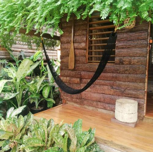 a hammock in front of a house with plants at Payag n' Kapitan, Experience pinubre living in Siquijor
