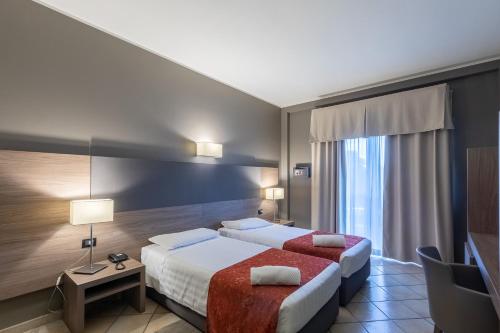 una camera d'albergo con due letti e una finestra di Hotel Sunflower a Milano