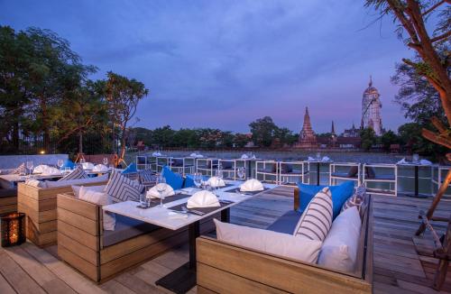 a restaurant with couches and tables on a deck at Sala Ayutthaya in Phra Nakhon Si Ayutthaya
