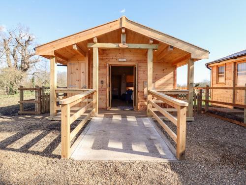 a woodenshed with a door in the middle at Clover Lodge in Leiston