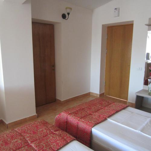 a room with two beds and a door at Hotel Regal in Eforie Nord