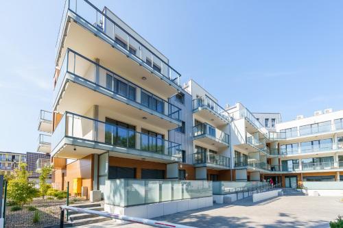 un edificio de apartamentos con balcones en un lateral en Ustronie Apartments 20 m do plaży en Ustronie Morskie
