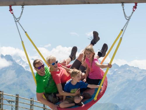 a group of people sitting on a swing at Apartment in Wald near Krimml Waterfalls in Wald im Pinzgau