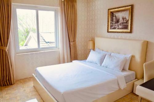 - une chambre avec un lit blanc et une fenêtre dans l'établissement Golden Hotel & Apartment, à Hô-Chi-Minh-Ville