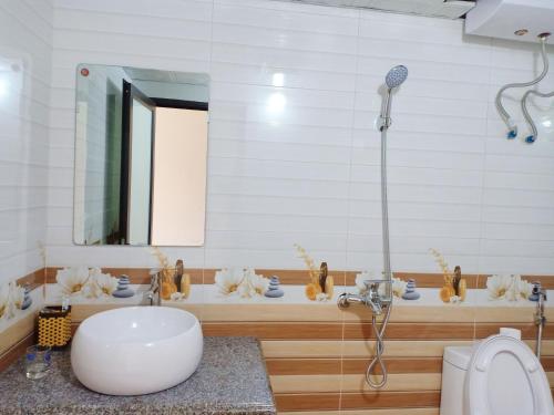 een badkamer met een wastafel en een douche bij Orchids Hotel in Sa Pa