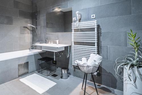 a bathroom with a sink and a mirror and a tub at Vila Vipolže - Rooms & J. Suites in Vipolže