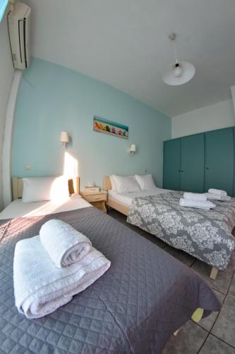 two beds in a room with towels on them at Dinos Studios in Paralía Kanalíou