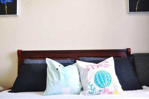 eine Gruppe von Kissen auf einem Bett in der Unterkunft BREATHTAKING TAAL VIEW! TAGAYTAY WIND RESIDENCES MODERN SUITE 23F in Tagaytay