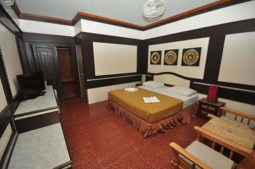 a bedroom with a bed and a tv in it at Phi Phi Rimlay Resort in Phi Phi Don