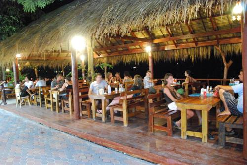 a group of people sitting at tables in a restaurant at Phi Phi Rimlay Resort in Phi Phi Don