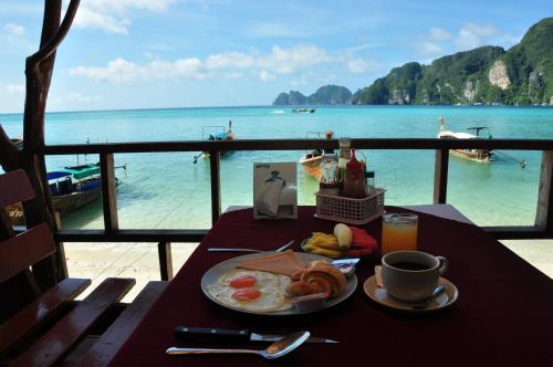 a table with a plate of eggs and a view of the ocean at Phi Phi Rimlay Resort in Phi Phi Don