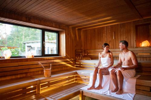 a man and a woman sitting in a sauna at Residenz Royal in Gmünd