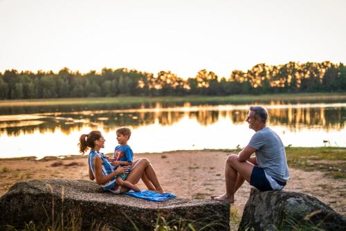 a family sitting on a rock near a lake at Residenz Royal in Gmünd