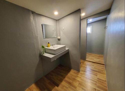a bathroom with a white sink and a mirror at Wooden hostel in Chiang Mai