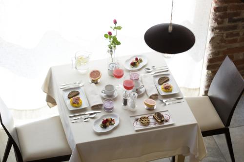 Una mesa blanca con platos de comida encima. en Cascina Marcantonio, en Acqui Terme