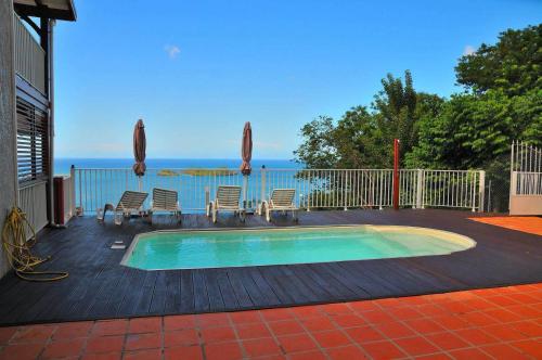una pequeña piscina en una terraza con sillas en Eden de Caraïbes, en Bouillante