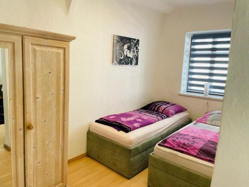 1 dormitorio con 2 camas individuales y ventana en Ferienwohnung Stohn, en Pirna