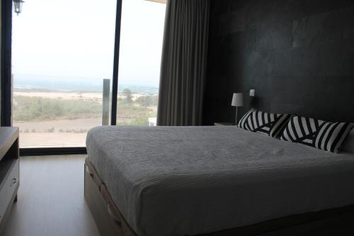 a bedroom with a large bed and a large window at Apartamentos Tocororo in Cotillo