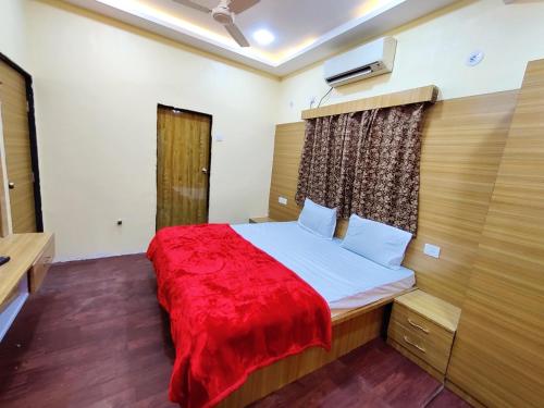 ein Schlafzimmer mit einem Bett mit einer roten Decke in der Unterkunft Hotel Family Inn FOREIGN GUEST ONLY in Aurangabad