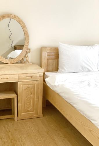a bedroom with a bed with a mirror and a table at Gia An - hotel in Dalat in Da Lat