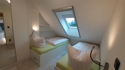 A bed or beds in a room at Grüne Farm (FeWo West)