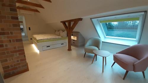 a bedroom with a bed and a chair and a window at Grüne Farm (FeWo West) in Burg Kauper