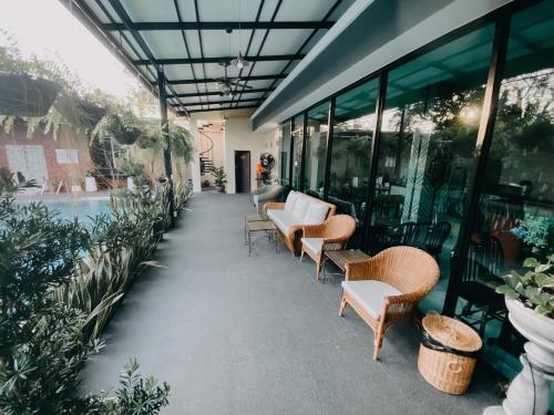 a patio with chairs and a pool in a building at Baan Chao Khun Hotel in Ban Khlong Lat Bua Khao