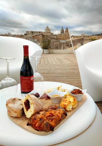 a plate of food on a table with a bottle of wine at Terrazza Dei Sogni in Ragusa