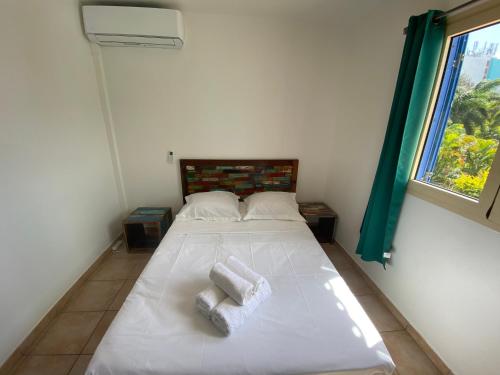 une chambre avec un lit avec deux serviettes dessus dans l'établissement PALM SPRING, au Gosier
