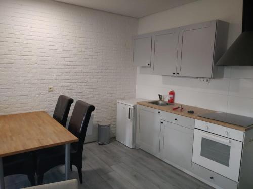 a kitchen with white cabinets and a table with chairs at Hof van Sellingen in Sellingen