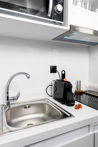 a kitchen with a sink and a microwave at CubeStudio21 in Kallithea Halkidikis
